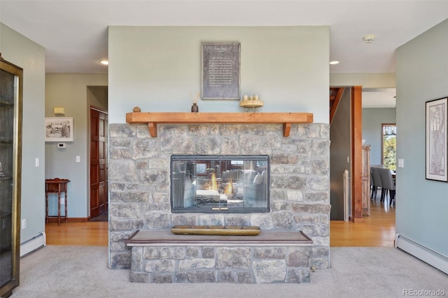 details featuring carpet flooring, a stone fireplace, and a baseboard heating unit