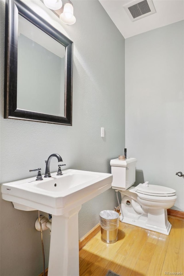 bathroom with hardwood / wood-style floors, toilet, and sink