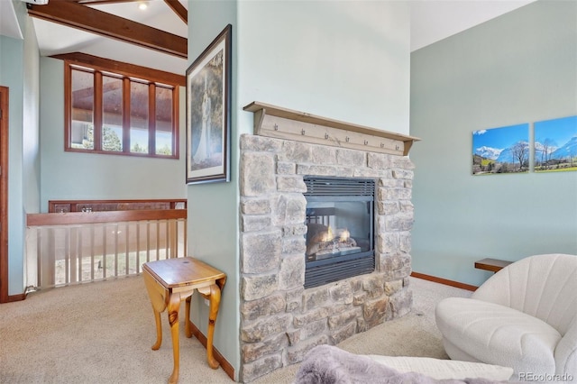 living room with carpet flooring, vaulted ceiling with beams, a healthy amount of sunlight, and a stone fireplace