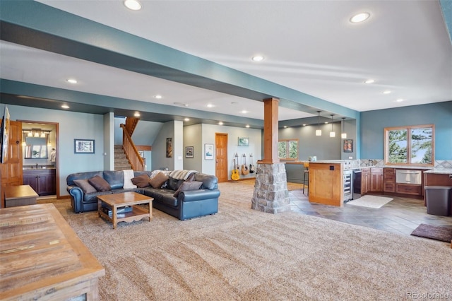 carpeted living room with wine cooler and sink