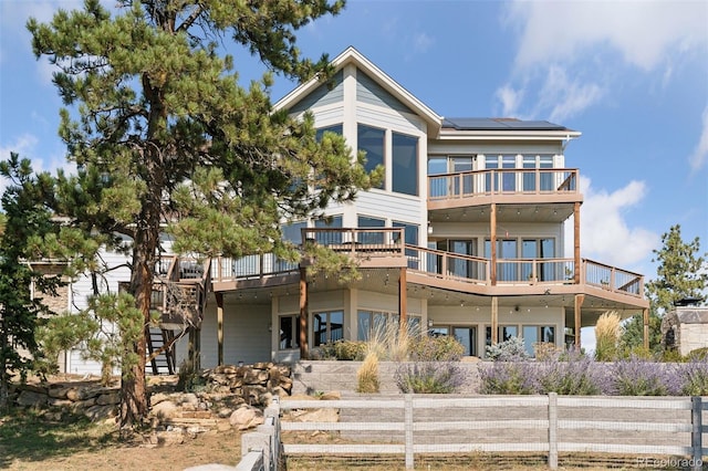 12421 High Country Trl, Littleton, CO 80127 - back of property featuring solar panels, a wooden deck, stairs, and a balcony