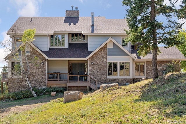 rear view of property with a deck and a yard