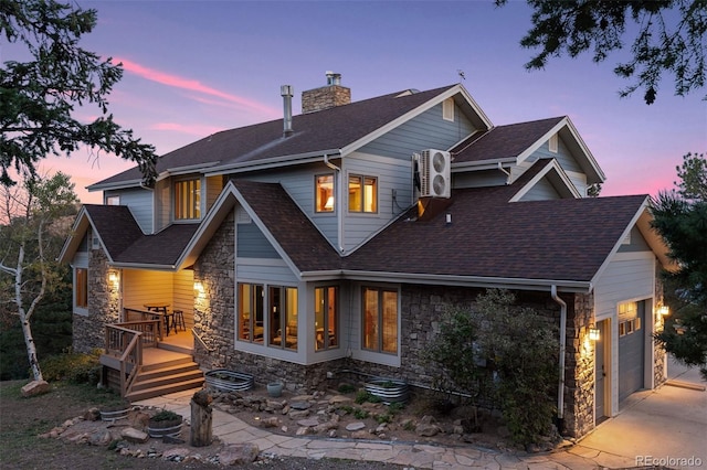 back house at dusk featuring a garage