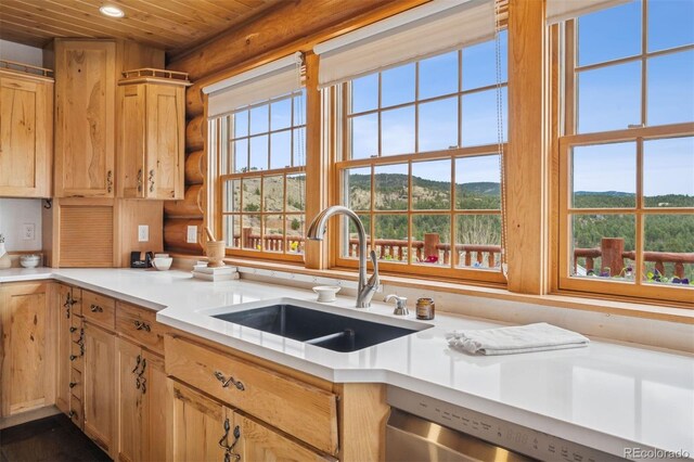 kitchen featuring a sink, wooden ceiling, light countertops, a mountain view, and log walls
