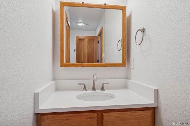 bathroom with vanity and a textured wall
