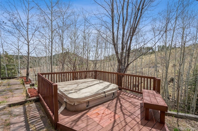 wooden terrace with a covered hot tub and a mountain view