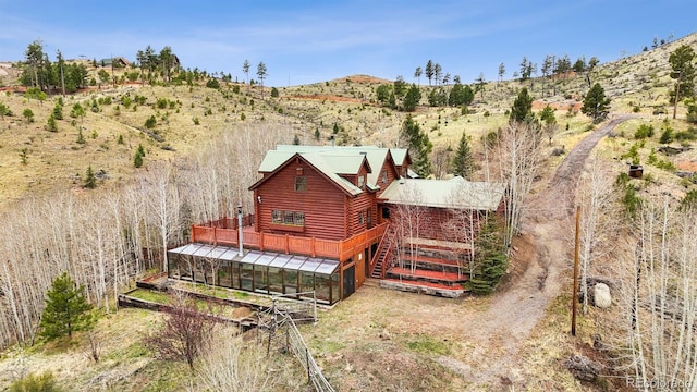 rear view of house with a wooden deck and log veneer siding