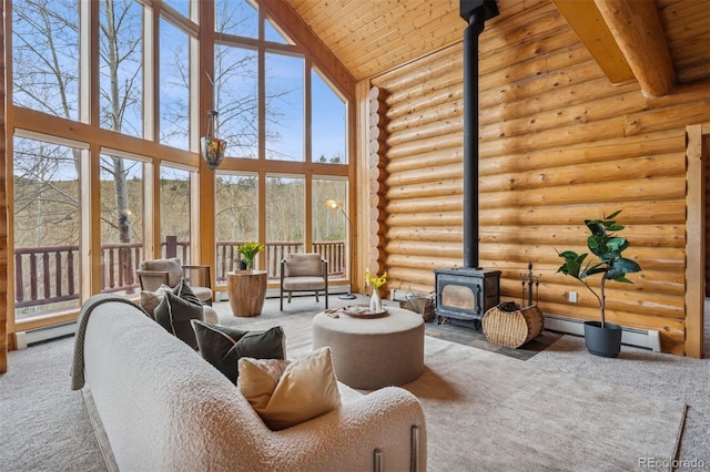 living room with wooden ceiling, carpet, a wood stove, and a towering ceiling