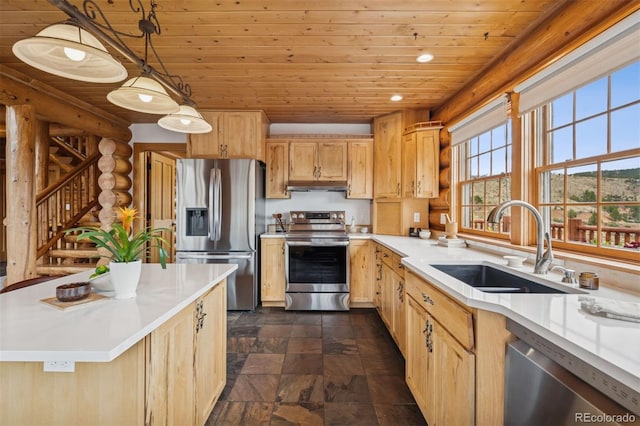 kitchen with a sink, stone finish flooring, appliances with stainless steel finishes, and wooden ceiling
