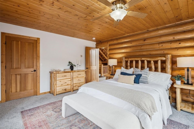 bedroom with carpet flooring, wood ceiling, baseboards, and log walls