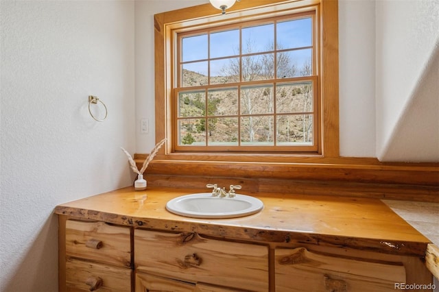 bathroom featuring vanity and a textured wall