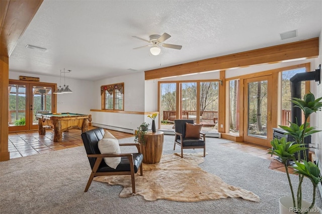 living room with pool table, plenty of natural light, baseboard heating, and a textured ceiling