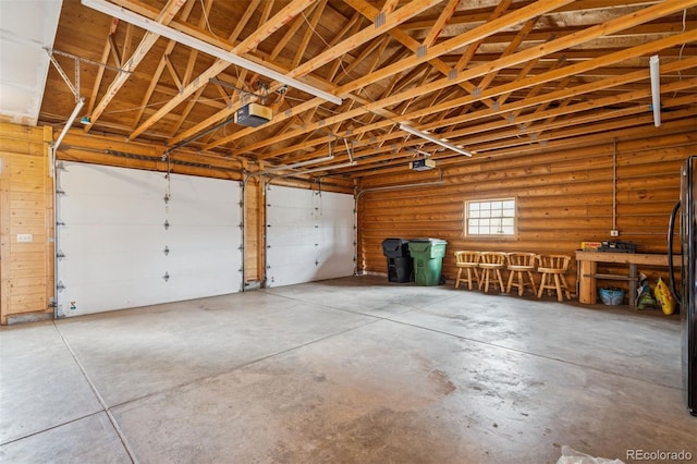 garage featuring a garage door opener and freestanding refrigerator