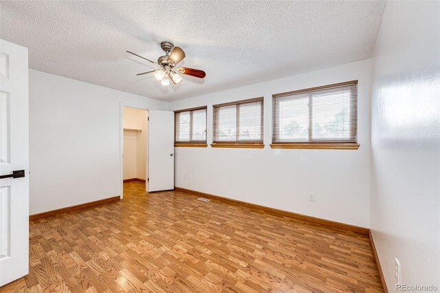 7840 W Portland Ave, Littleton, CO 80128 - unfurnished room featuring healthy amount of natural light, light wood finished floors, ceiling fan, and a textured ceiling