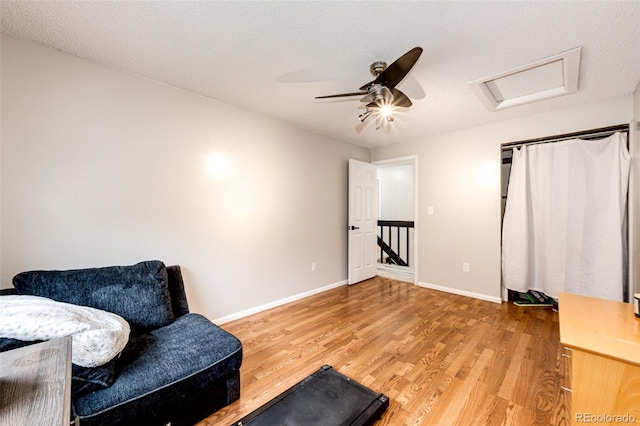 7840 W Portland Ave, Littleton, CO 80128 - sitting room with attic access, light wood finished floors, an upstairs landing, and ceiling fan
