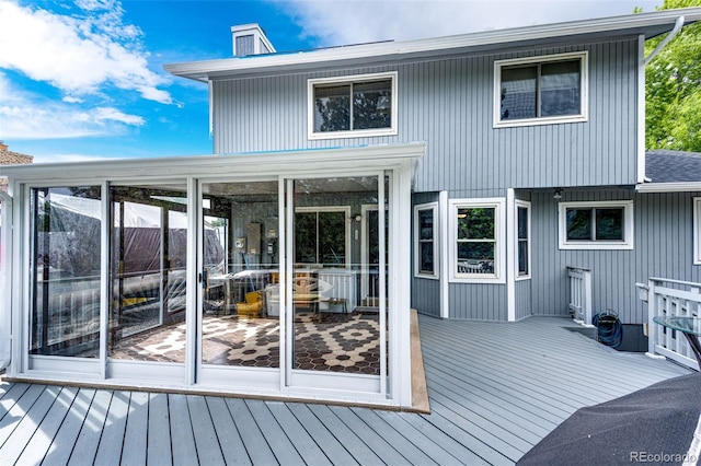 7840 W Portland Ave, Littleton, CO 80128 - back of house featuring a wooden deck, a chimney, and a sunroom