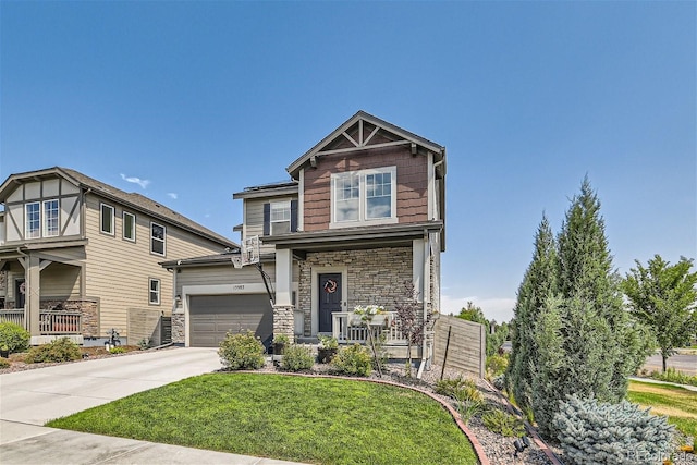 craftsman-style home with covered porch, a front yard, and a garage