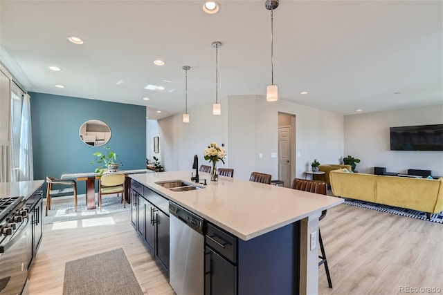 kitchen with dishwasher, sink, hanging light fixtures, a kitchen breakfast bar, and an island with sink