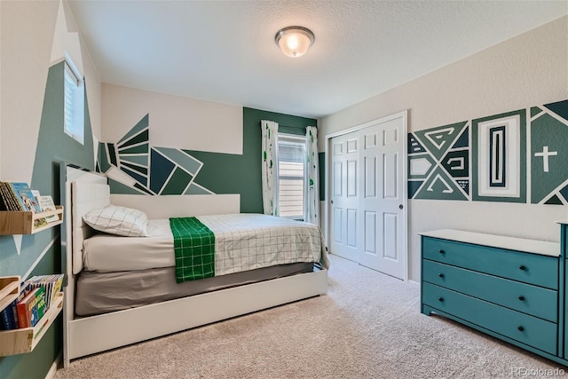 carpeted bedroom with a textured ceiling and a closet