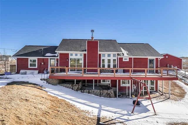 snow covered house with a deck and a chimney