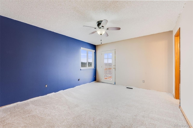 spare room featuring ceiling fan, a textured ceiling, visible vents, and light colored carpet