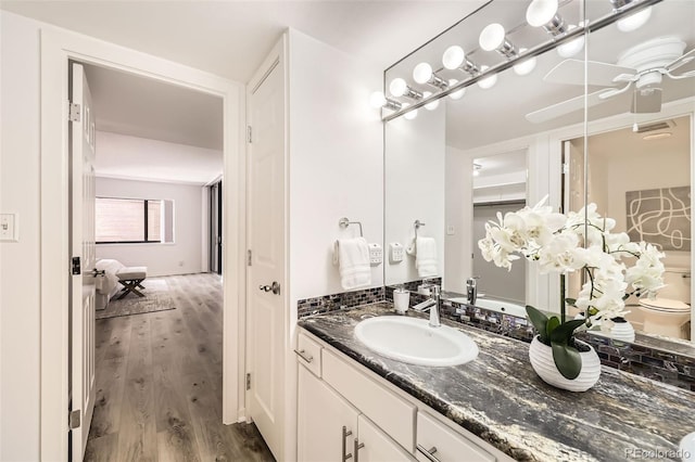 1551 Larimer St Unit 703, Denver, CO 80202 - bathroom with wood finished floors, vanity, ceiling fan, and toilet