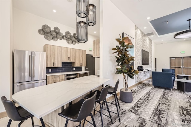 1551 Larimer St Unit 703, Denver, CO 80202 - kitchen featuring light brown cabinets, light stone counters, appliances with stainless steel finishes, a kitchen bar, and recessed lighting