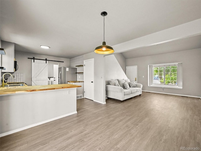3535 Beechwood Ct, Colorado Springs, CO 80918 - kitchen with a barn door, dark wood finished floors, wood counters, and stainless steel refrigerator with ice dispenser