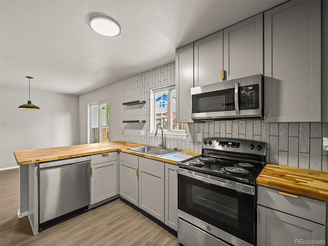 3535 Beechwood Ct, Colorado Springs, CO 80918 - kitchen featuring wood counters, appliances with stainless steel finishes, a sink, tasteful backsplash, and gray cabinetry
