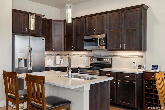 kitchen featuring light countertops, tasteful backsplash, dark brown cabinetry, and stainless steel appliances