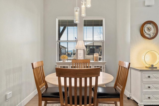 dining space with light wood-style flooring and baseboards