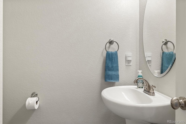 bathroom with a textured wall and a sink