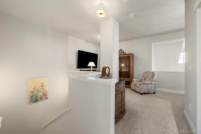 hallway with baseboards and light carpet