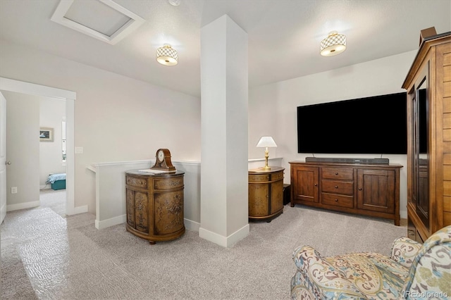 living area featuring light carpet, attic access, and baseboards