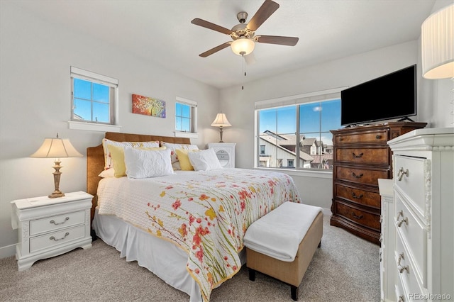 bedroom with a ceiling fan and light carpet