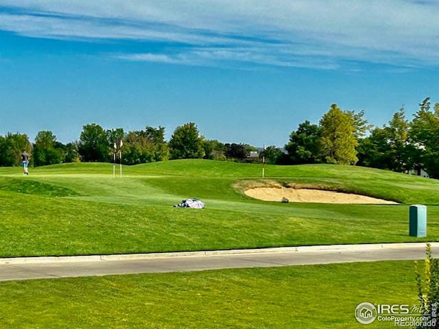 view of home's community featuring a lawn and golf course view