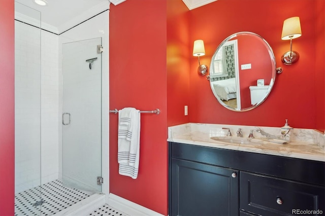 bathroom with baseboards, a shower stall, vanity, and ensuite bathroom