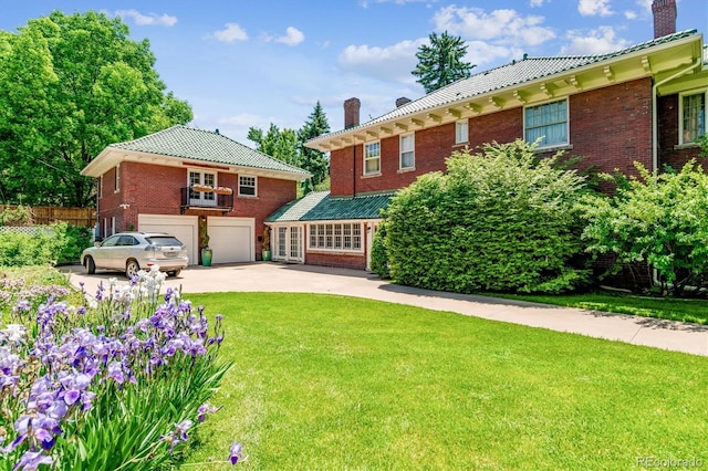 view of front of house featuring an attached garage, brick siding, concrete driveway, a chimney, and a front yard