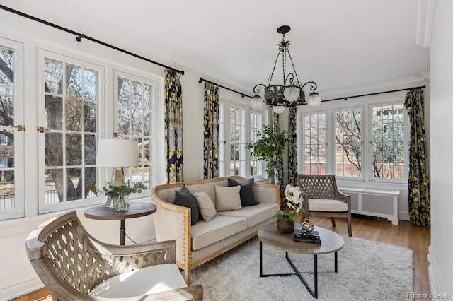 sunroom featuring radiator and a chandelier