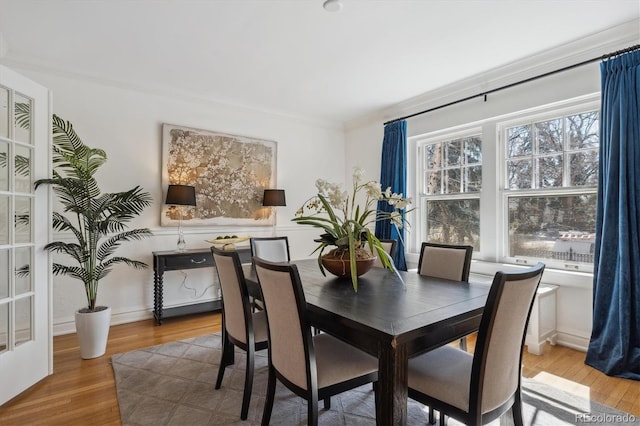 dining room with wood finished floors and crown molding