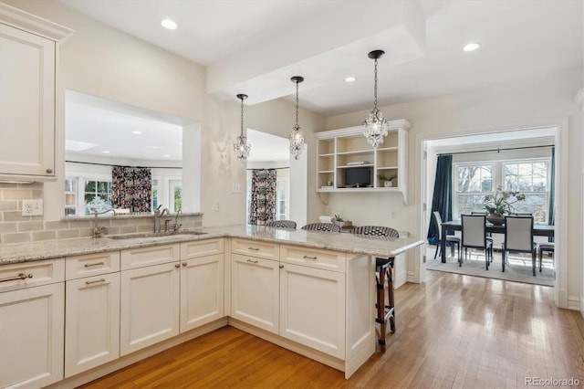 kitchen featuring open shelves, light wood finished floors, and plenty of natural light