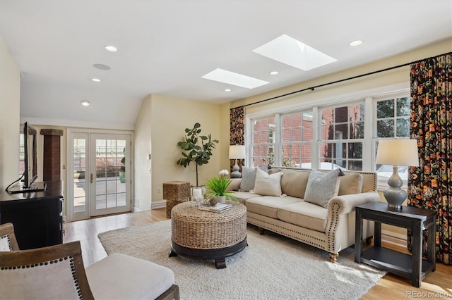 living room featuring light wood-style floors, a wealth of natural light, and french doors