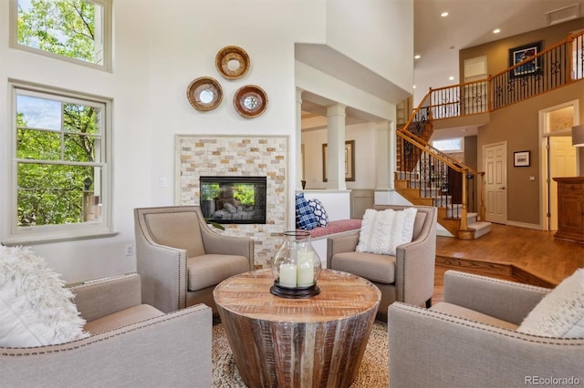9880 E Progress Cir, Greenwood Village, CO 80111 - living room featuring a high ceiling, stairway, wood finished floors, a tile fireplace, and recessed lighting