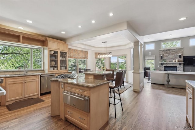 9880 E Progress Cir, Greenwood Village, CO 80111 - kitchen featuring a warming drawer, stainless steel dishwasher, a kitchen island, a kitchen breakfast bar, and ornate columns