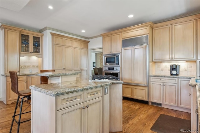 9880 E Progress Cir, Greenwood Village, CO 80111 - kitchen with built in appliances, tasteful backsplash, a kitchen island, light wood finished floors, and light brown cabinets