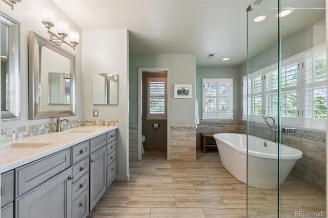 9880 E Progress Cir, Greenwood Village, CO 80111 - bathroom featuring toilet, double vanity, a freestanding bath, and recessed lighting