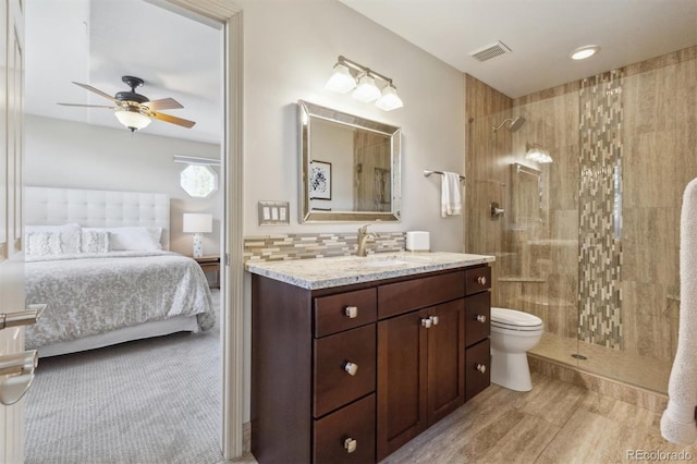 9880 E Progress Cir, Greenwood Village, CO 80111 - bathroom featuring ceiling fan, a tile shower, ensuite bathroom, toilet, and vanity