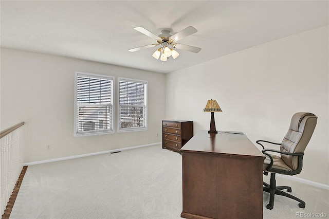 office featuring light carpet, ceiling fan, visible vents, and baseboards