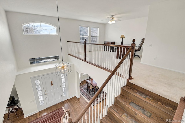 entryway featuring a notable chandelier, arched walkways, wood finished floors, and baseboards