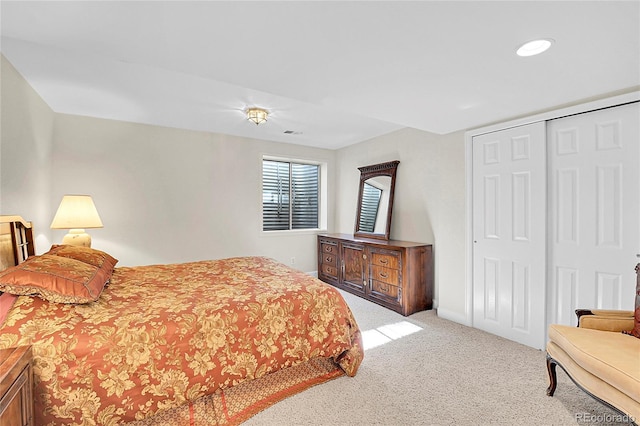 bedroom featuring a closet, light carpet, visible vents, and baseboards